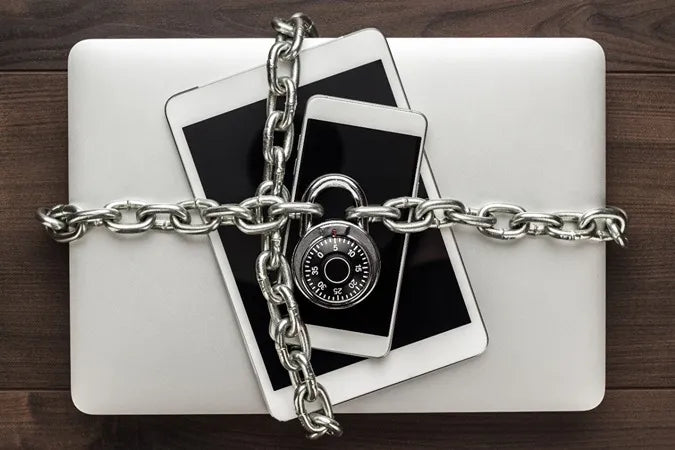 Laptop and smartphones secured with chain and padlock, data protection by Prime Tech Support Miami